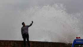 Un hombre se toma un selfie junto a una ola antes de la llegada del ciclón Biparjoy a Pakistán.