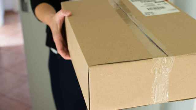 Un repartidor entrega un paquete tras un envío