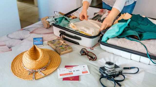 Una mujer preparando su maleta para las vacaciones de verano.