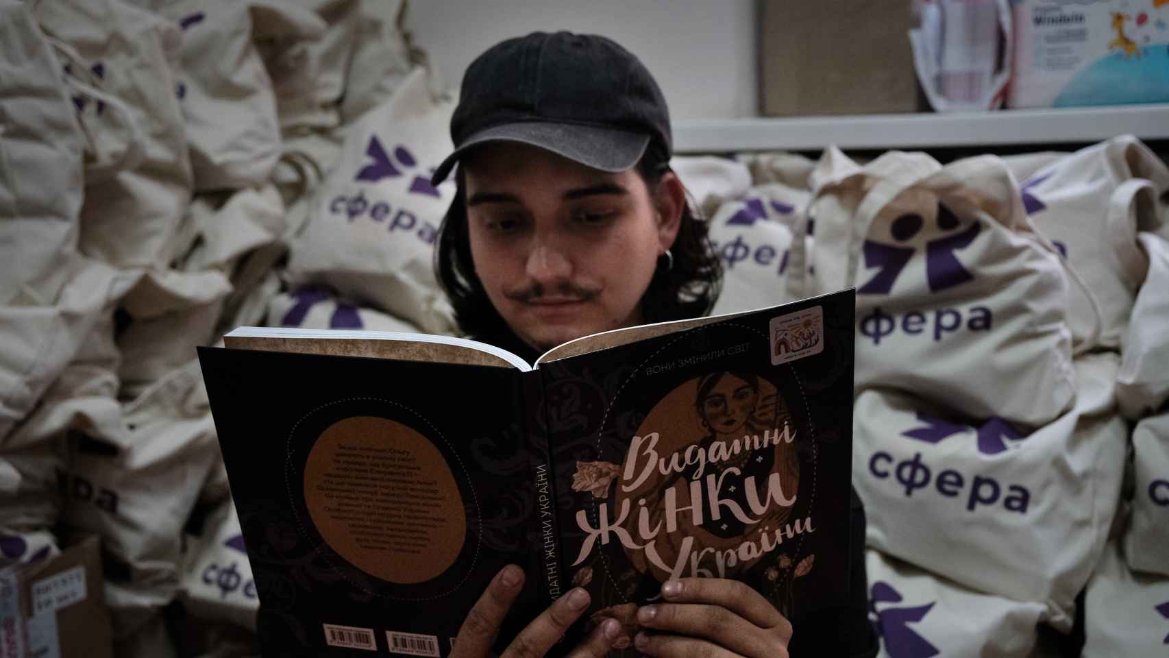 Yarik Rybkin mira uno de los libros, con historias de mujeres, que ha editado la ONG donde trabaja, en Járkov.