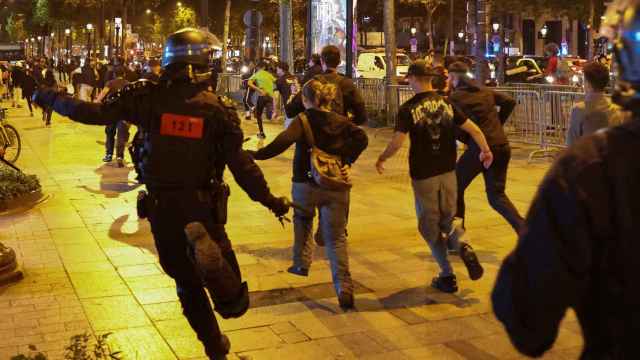 Varias personas corren seguidas por agentes de policía en los Campos Elíseos de París, el pasado sábado.