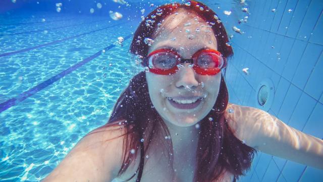 Una mujer bajo el agua con gafas de buceo.