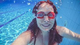 Una mujer bajo el agua con gafas de buceo.