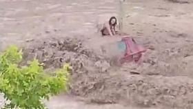 Una mujer espera subida a un coche a que lleguen los operarios de emergencias durante las inundaciones en Zaragoza.