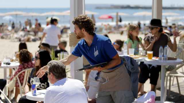 Un camarero sirve una mesa en una playa alicantina, hace unos meses.