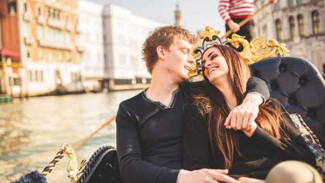 Una pareja en una góndola por los canales de Venecia.