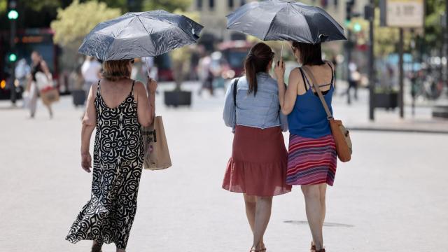 Varias personas se refugian del sol durante la ola de calor.