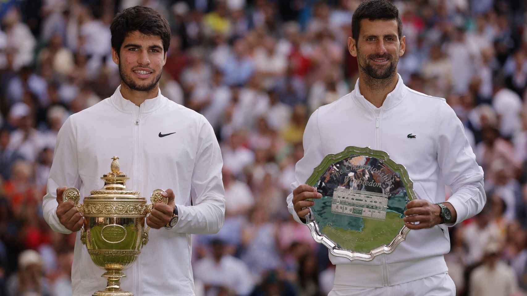 Alcaraz posa con el trofeo de ganador de Wimbledon junto a Novak Djokovic.