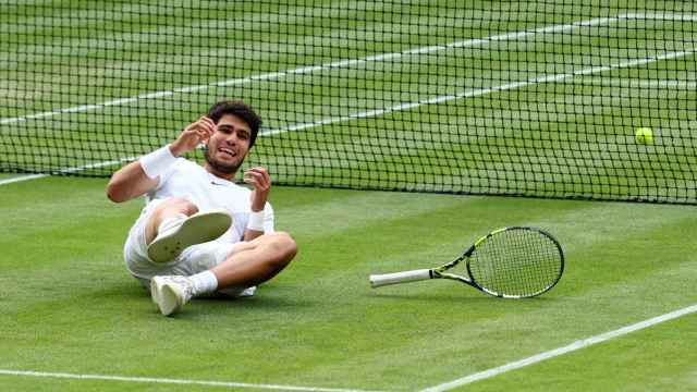 Carlos Alcaraz, en el suelo, celebra su victoria en Wimbledon.