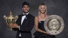 Carlos Alcaraz y Marketa Vondrousova, con sus trofeos de campeones de Wimbledon