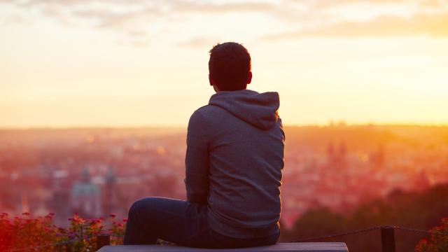 Persona esperando en un banco al atardecer. Foto: iStock.