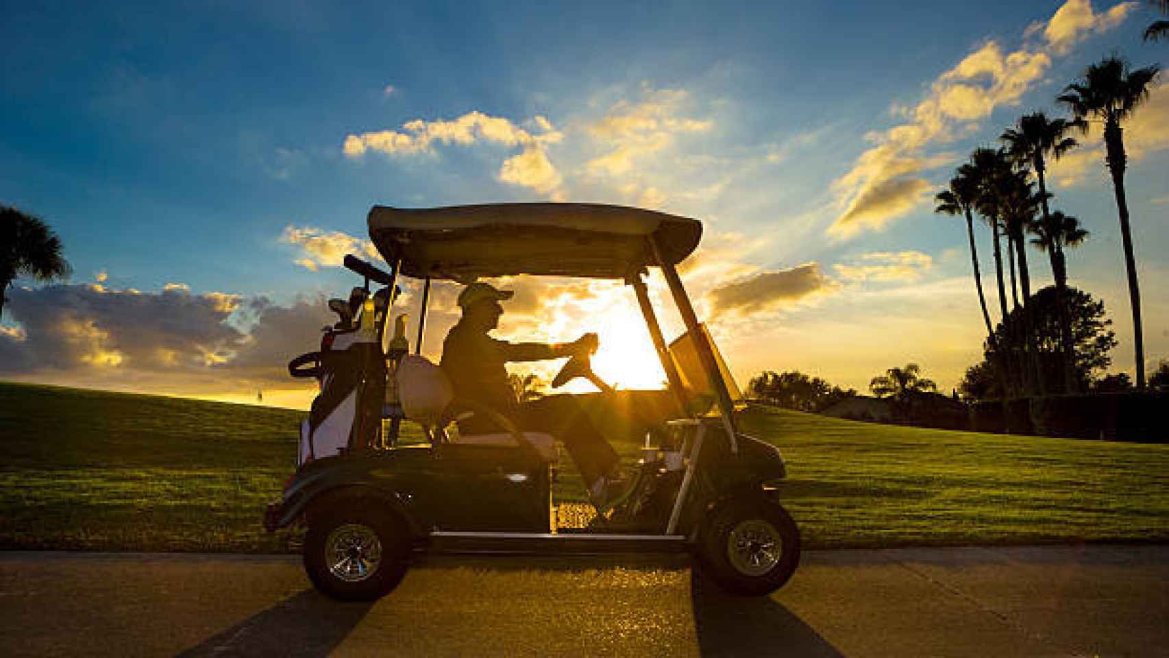 Un hombre conduciendo un carrito de golf