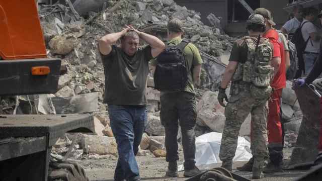 Un hombre llora la pérdida al lado de los restos mortales de su hijo en un edificio dañado en Odesa tras un bombardeo.