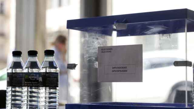 Una urna en un colegio electoral de Madrid, junto con botellas de agua