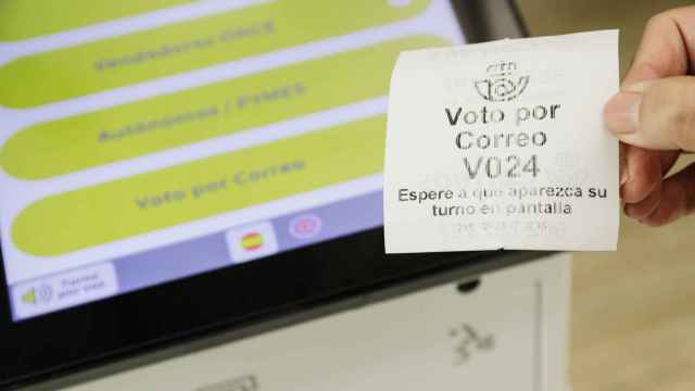Un ticket de turno de voto por correo en la oficina de Correos de la calle Conde de Peñalver, a 21 de julio de 2023