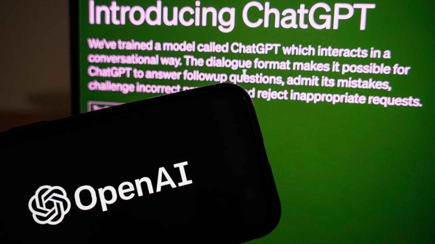 Un móvil con el logo de OpenAI y un monitor con ChatGPT.