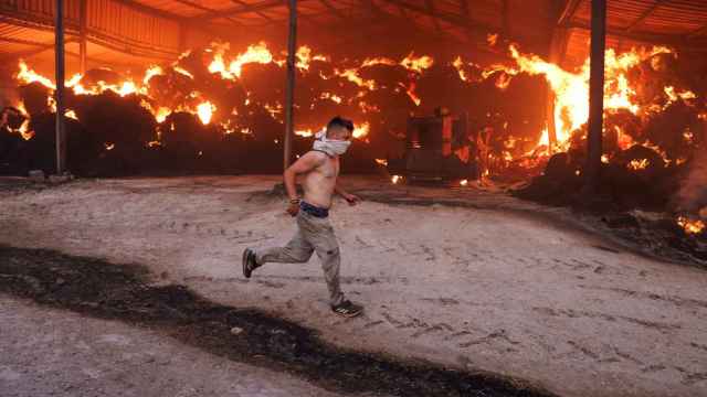 Un hombre corre en uno de los incendios de Grecia.