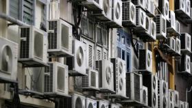 Edificio con aparatos de aire acondicionado en todas sus ventanas.