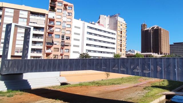 Imagen del moderno puente del CAC de Málaga y, al fondo, el edificio de Correos.