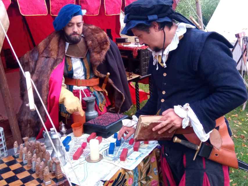 Dos hombres de la corte del emperador Carlos V despachan durante la celebración del mercado en Valcescapa