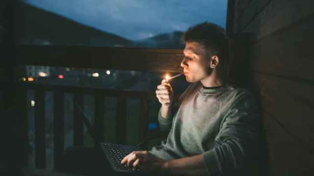 Hombre fumando en la terraza de su casa