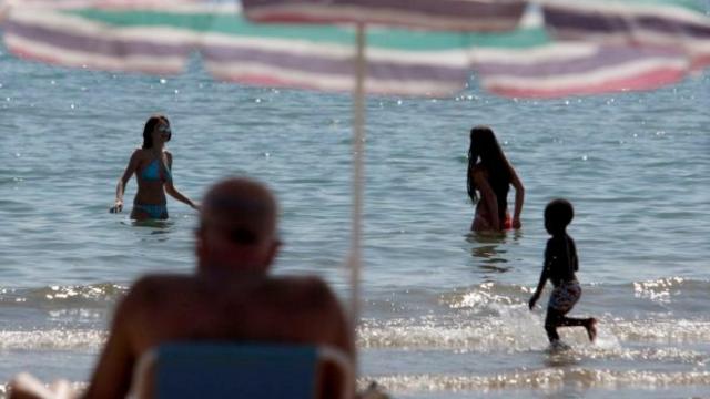 Varias personas jugando a las playas en una playa española.