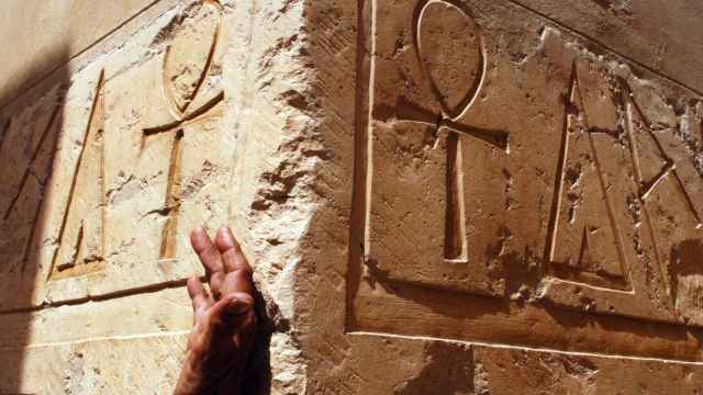 Mano de hombre cerca de jeroglíficos en Egipto (iStock)