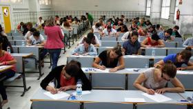 Varios candidatos examinándose en unas oposiciones.