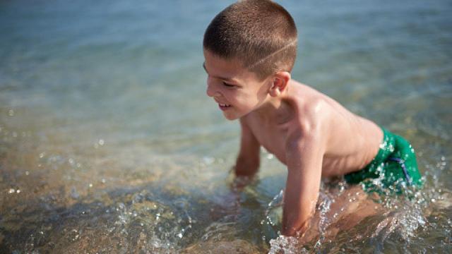 Imagen de archivo de un niño bañándose en la playa.