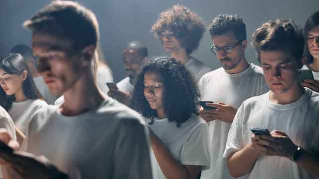 Imagen de archivo de un grupo de universitarios adictos al móvil.