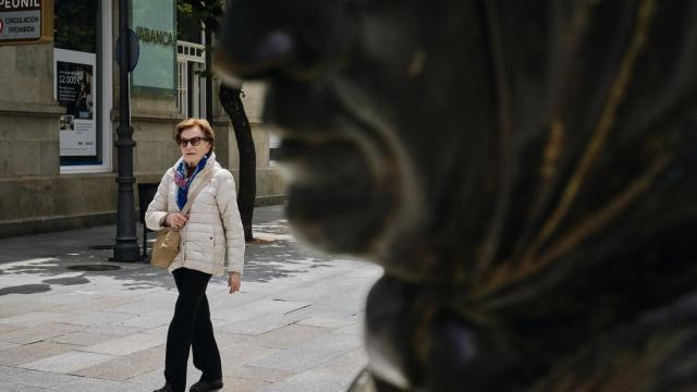 Una señora pasea por una de las calles de la ciudad.