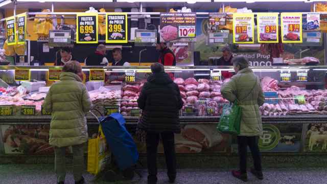 Varias mujeres compran en una carnicería de un mercado de Madrid.