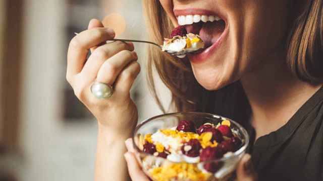 Mujer comiendo yogur con frutas. Foto: Getty Images