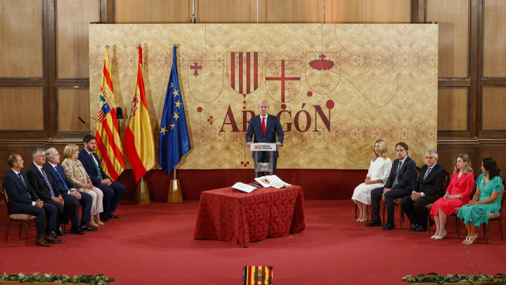 El presidente de Aragón, Jorge Azcón (c), durante su intervención este sábado en el acto en el que los diez consejeros del nuevo Gobierno de Aragón han tomado posesión de sus cargos en la Sala de la Corona del Edificio Pignatelli.