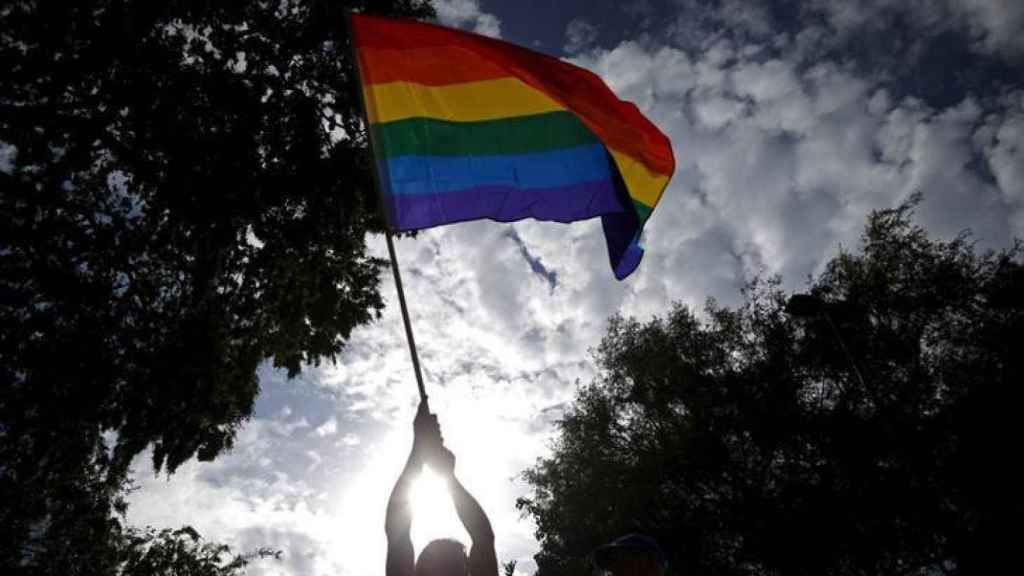 Un hombre hondea una bandera del colectivo LGBT.