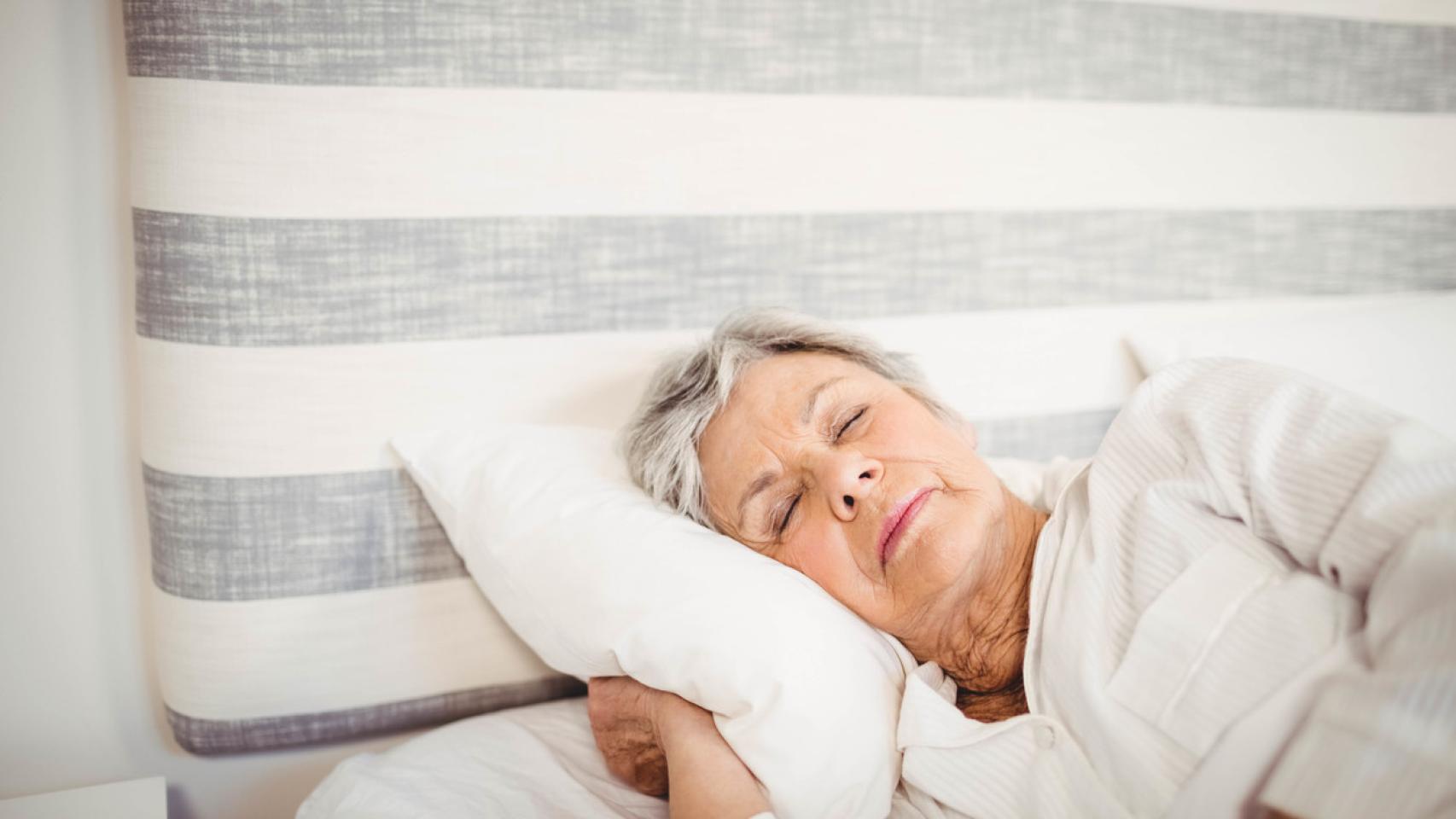 Imagen de archivo de una mujer mayor descansando en una cama.