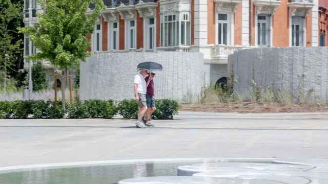 Una pareja pasea por Madrid durante el mes de agosto.