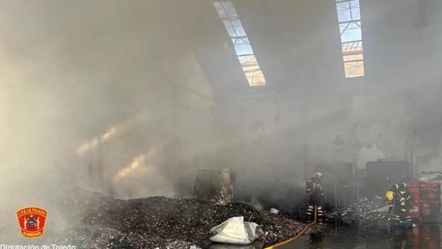 Los bomberos del CPEIS de Toledo trabajando en la nave incendiada.