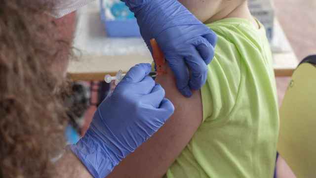 Una enfermera vacunando a un niño.