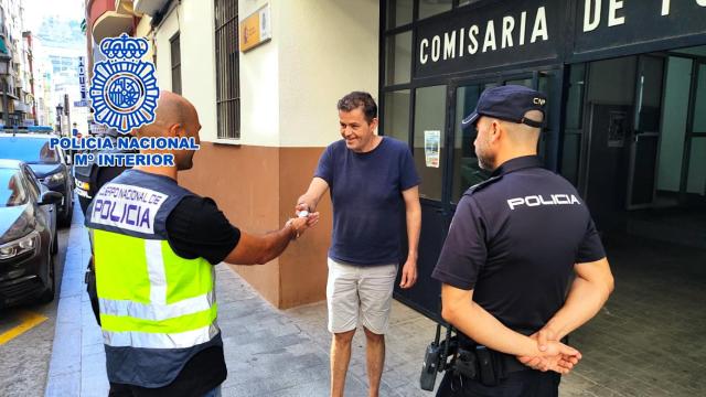 Los agentes de la Policía Nacional entregan el reloj recuperado a una de las víctimas de los supuestos agresores.