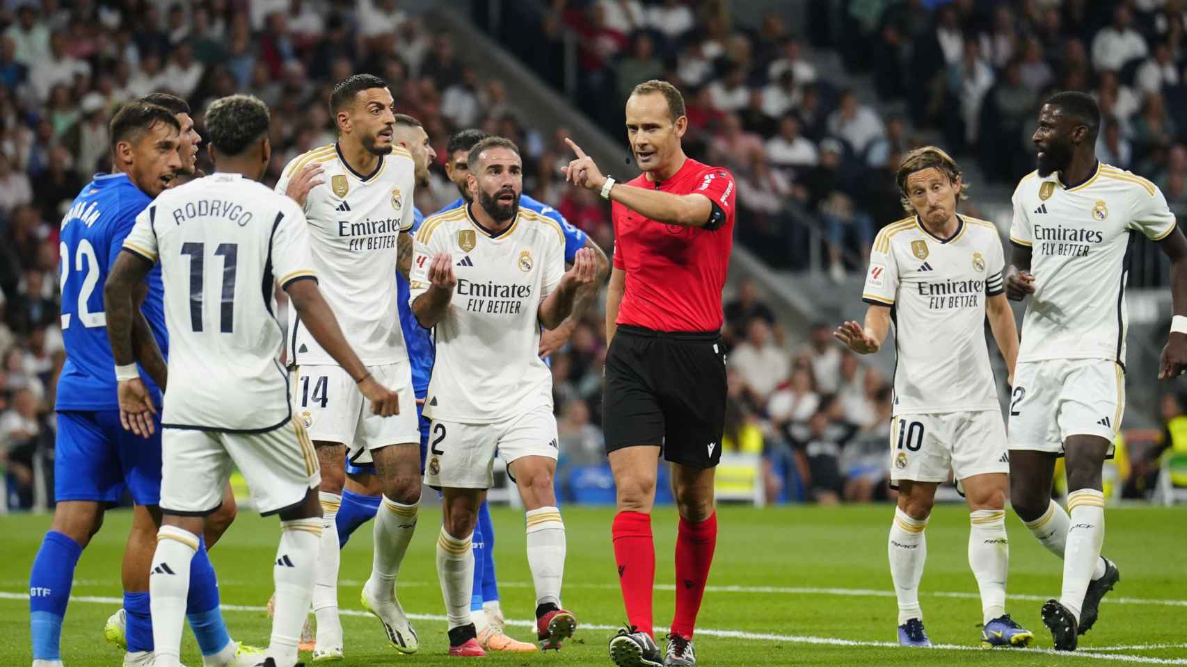 Los futbolistas del Real Madrid protestan ante Melero López durante el partido contra el Getafe