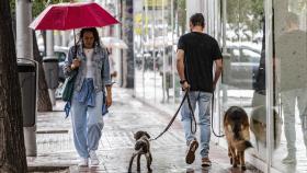 Dos personas caminan bajo la lluvia en Madrid