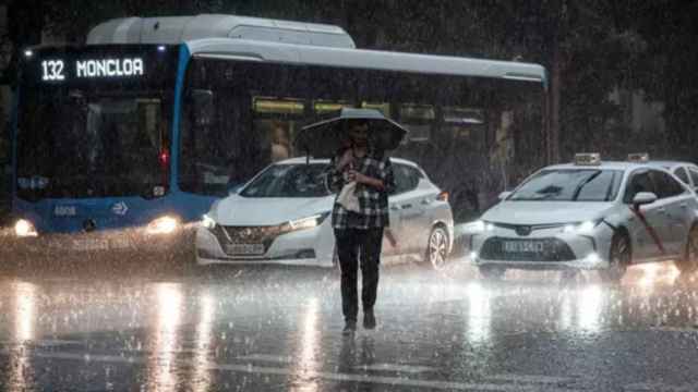 Una persona cruza la calle bajo la lluvia en Madrid.