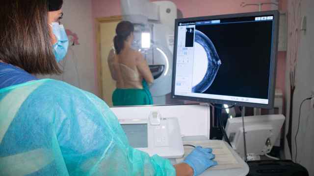 Una sanitaria realiza una mamografía a una joven.