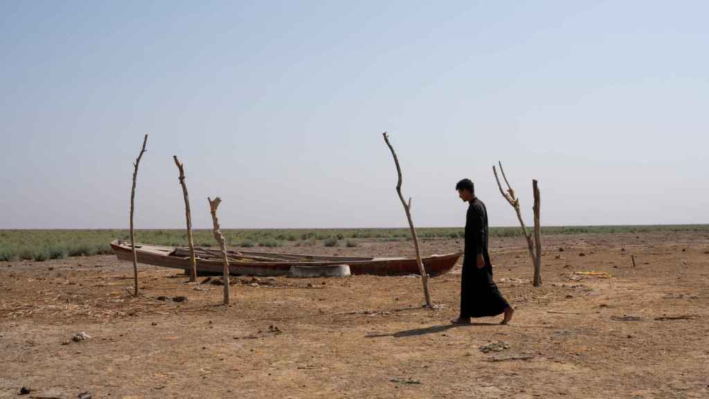Un hombre camina por las marismas secas de Chebayesh, en Dhi Qarç (Irak).