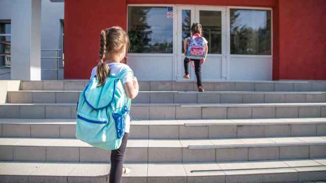 Dos niñas entran a un centro escolar.