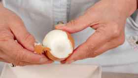 Una persona quita la cáscara de un huevo
