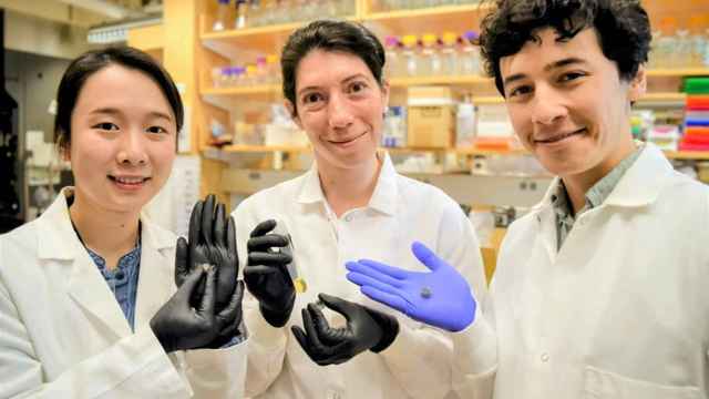Los investigadores del MIT sujetando la pastilla inteligente en la mano.