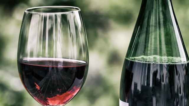 Imagen de archivo de una botella de vino tinto y de una copa.
