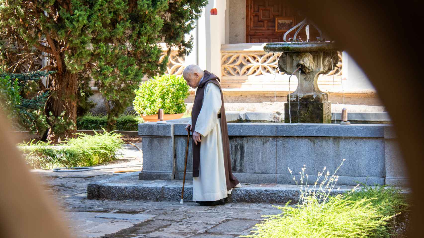 Uno de los monjes más veteranos de la Orden de San Jerónimo camina por el jardín del claustro tras la celebración de la misa conventual